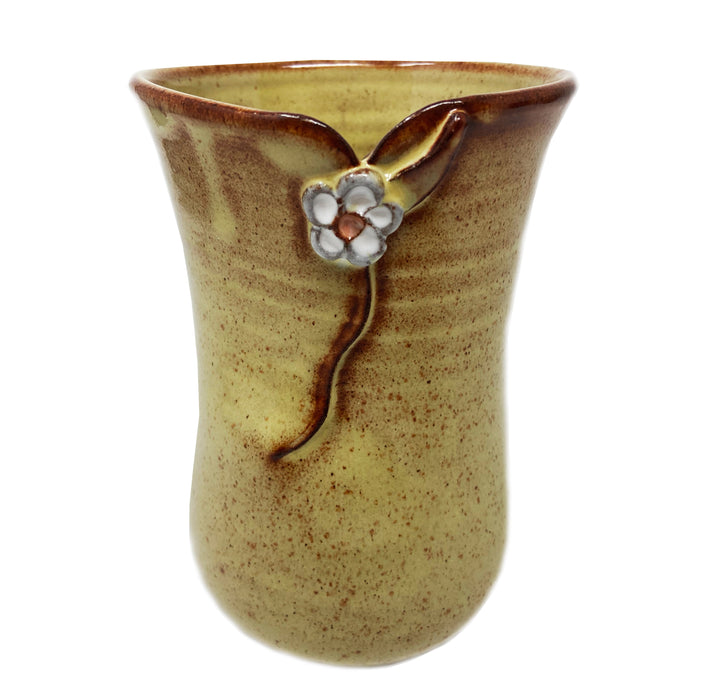 Pottery mug that is yellow with a white flower produced by Liza MacDonald