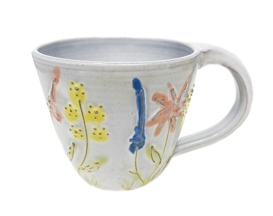 White pottery mug with light colored wildflowers made by Liza MacDonald